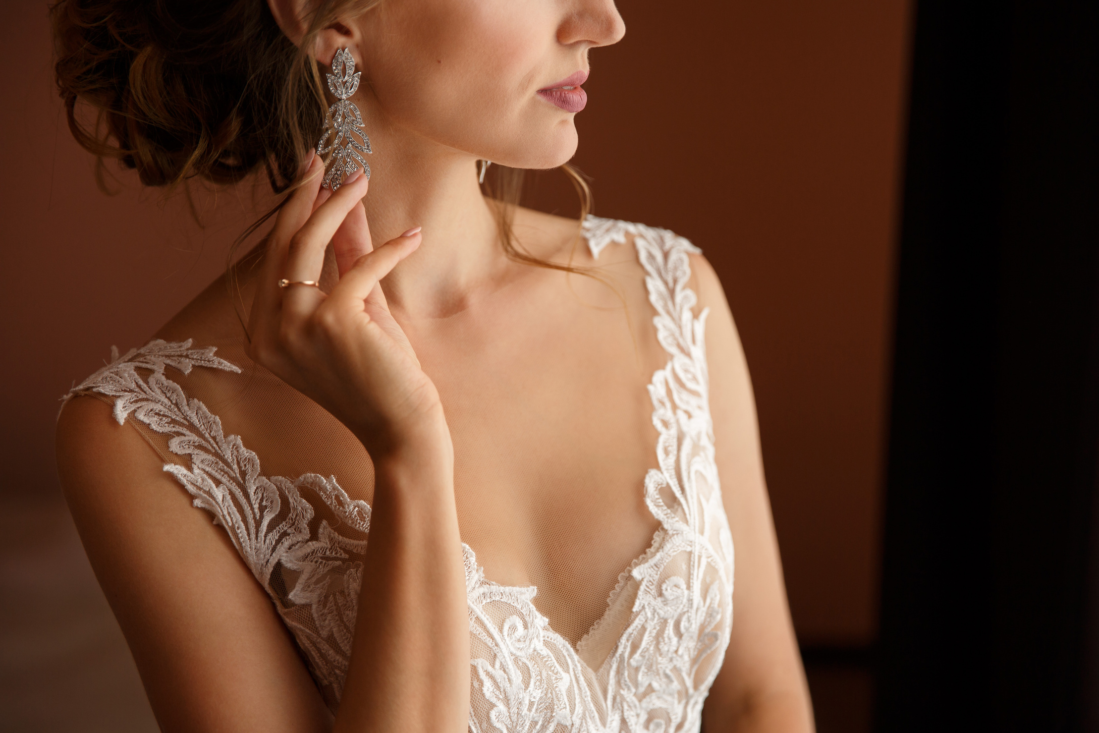 Wedding jewelry. Bride holding earrings